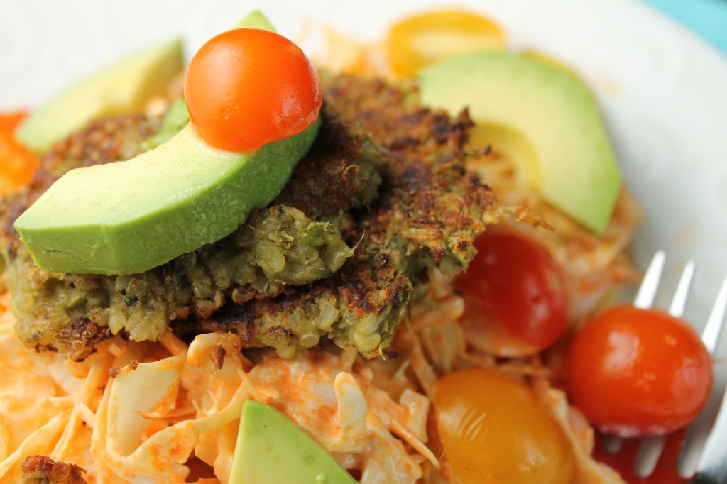 close up of quinoa and mung bean falafels topped with fresh avocado and cherry tomatoes