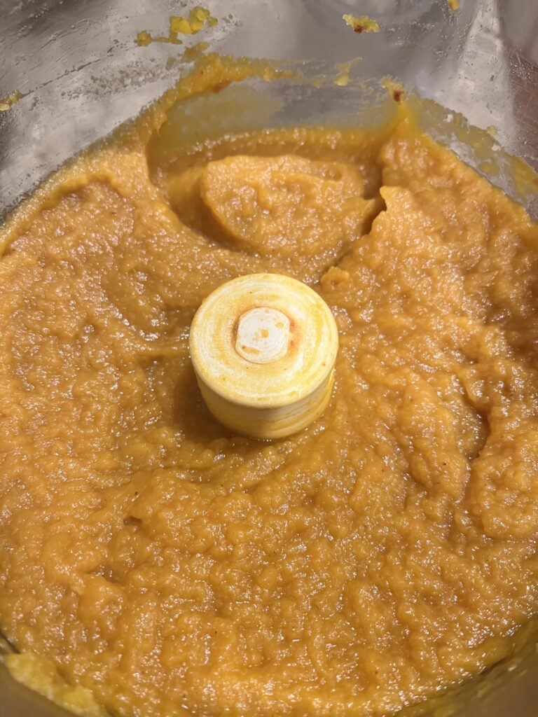 homemade pumpin puree in a food processor bowl from above