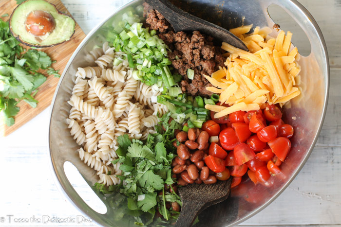 a birds eye view of a a tex mex pasta ingredients separated and ready to toss