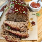 sliced meatloaf with tomato sauce topping and chopped parsley topping