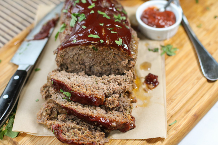 sliced meatloaf with tomato sauce topping and chopped parsley topping