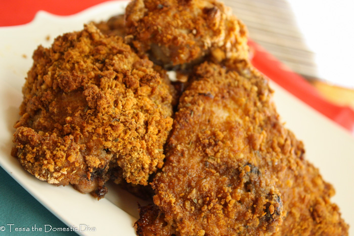 three oven fried chicken thighs on a white plate