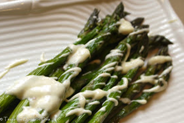 close up of grilled asparagus with a garlic lemon aioli drizzle