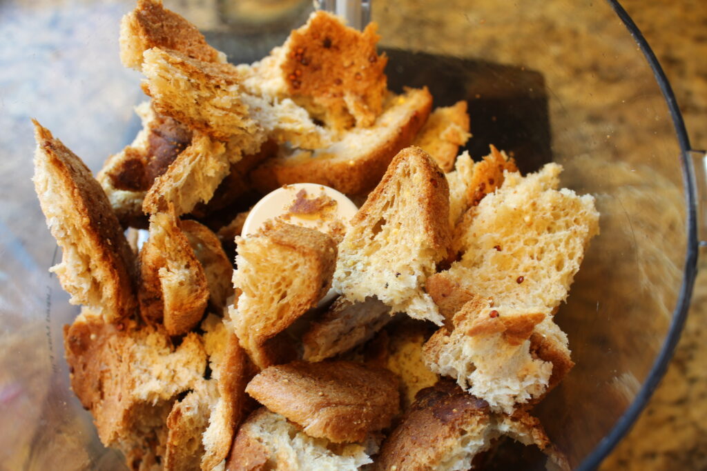 torn pieces of stale gluten free bread in a food processor bowl