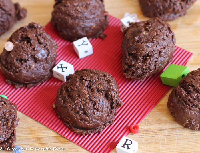 over head close up chocolate cookie ball with oat pieces and square white letter beads about