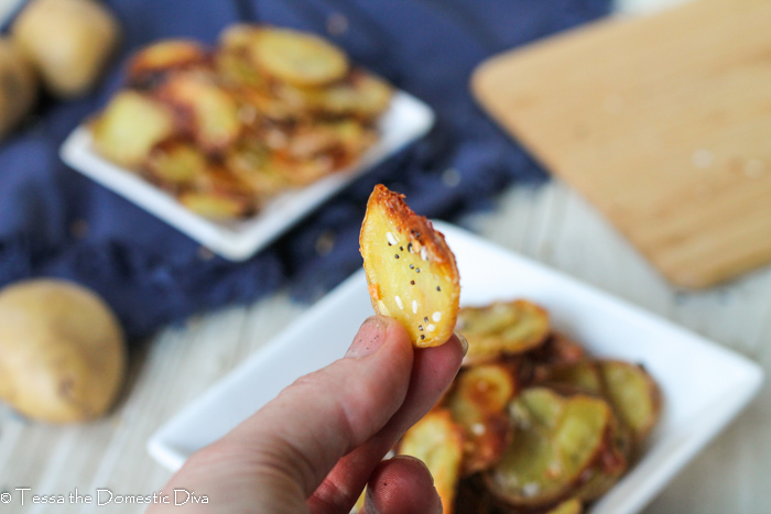 handheld homemade potato chip with everything seasoning