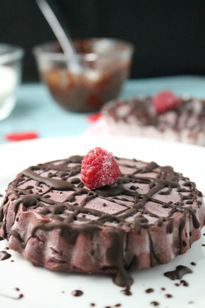 an individual raw chocolate tart with fresh raspberries