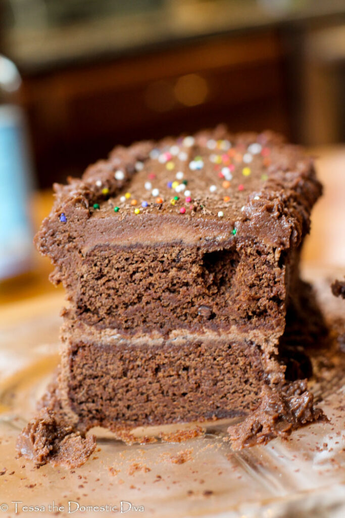 eye level sliced chocolate layer cake with cocoa frosting.