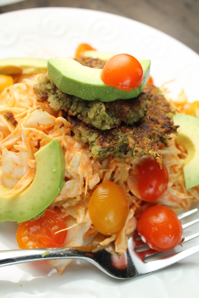 orange hued Thai slaw toped with crispy veggie burgers and avocado