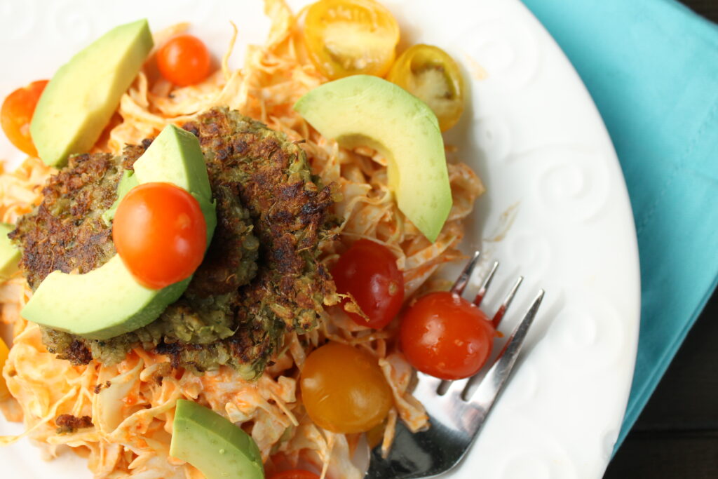 overhead shot of a white plate with munge bean falafels on a cabbage slaw