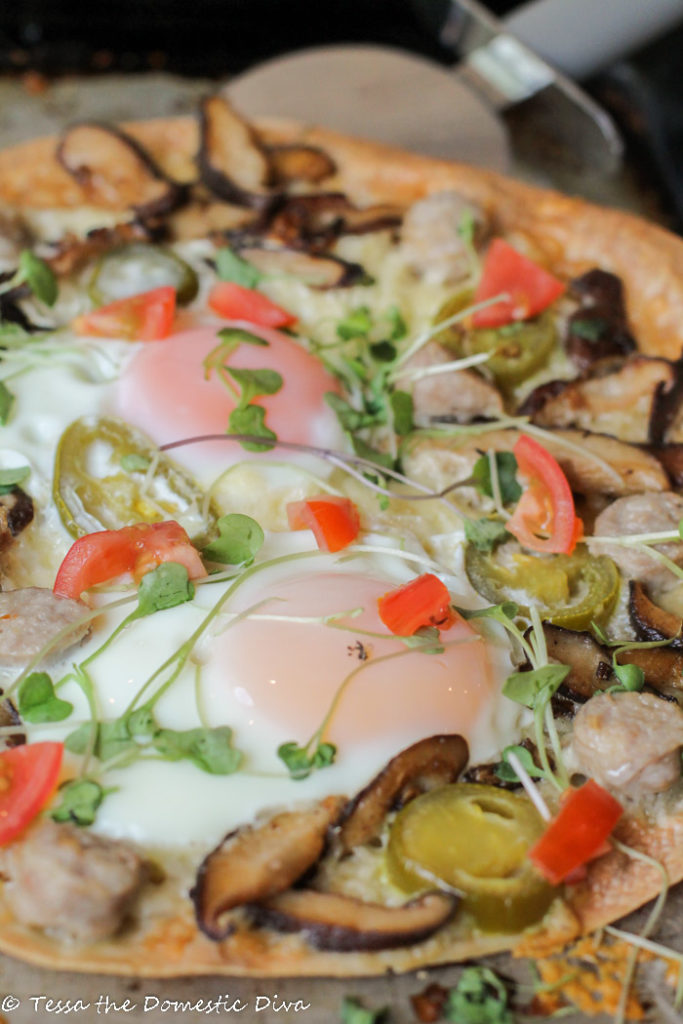 close up of a cripsy rice tortilla topped with sauteed veggies,eggs, and cheese