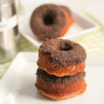 two baked cake style donuts dusted with a cinnamon sugar coating