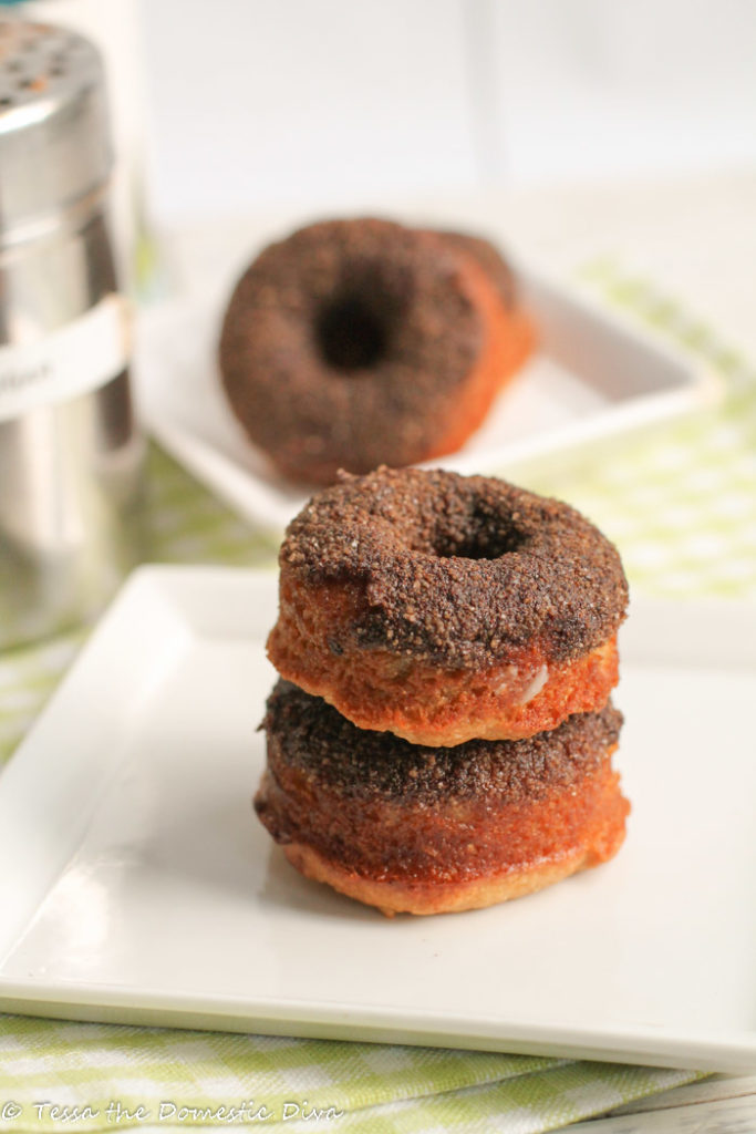 two baked cake style donuts dusted with a cinnamon sugar coating