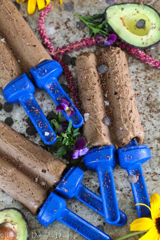 three homemade fudgesicles atop a distressed cookie sheet from overhead