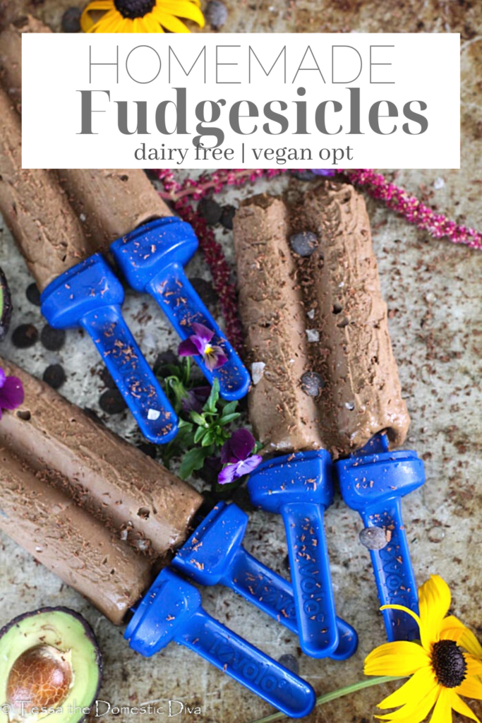 pinterest ready three homemade fudgsicles from overhead on a cookie sheet with flowers and avocado