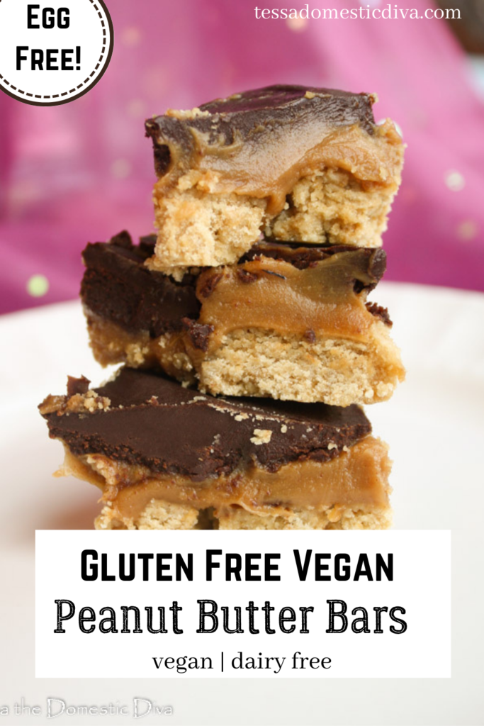 pinterest ready stacks of gluten free cookie bars with a creamy peanut butter filling and a chocolate topping on a white plate