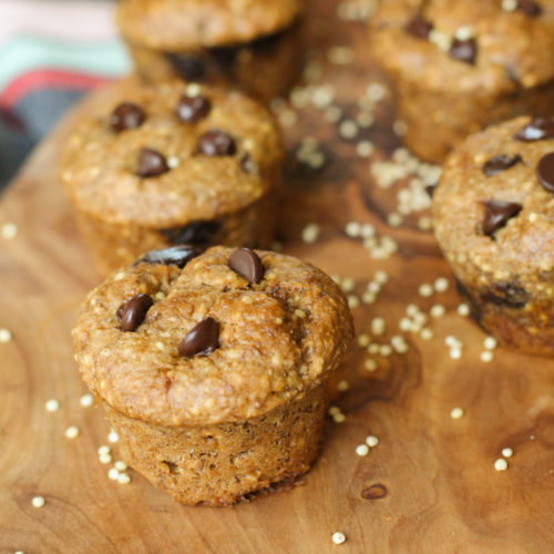 mini muffins studded with chococlate chips arranged on an olive wood cutting board with whole millet