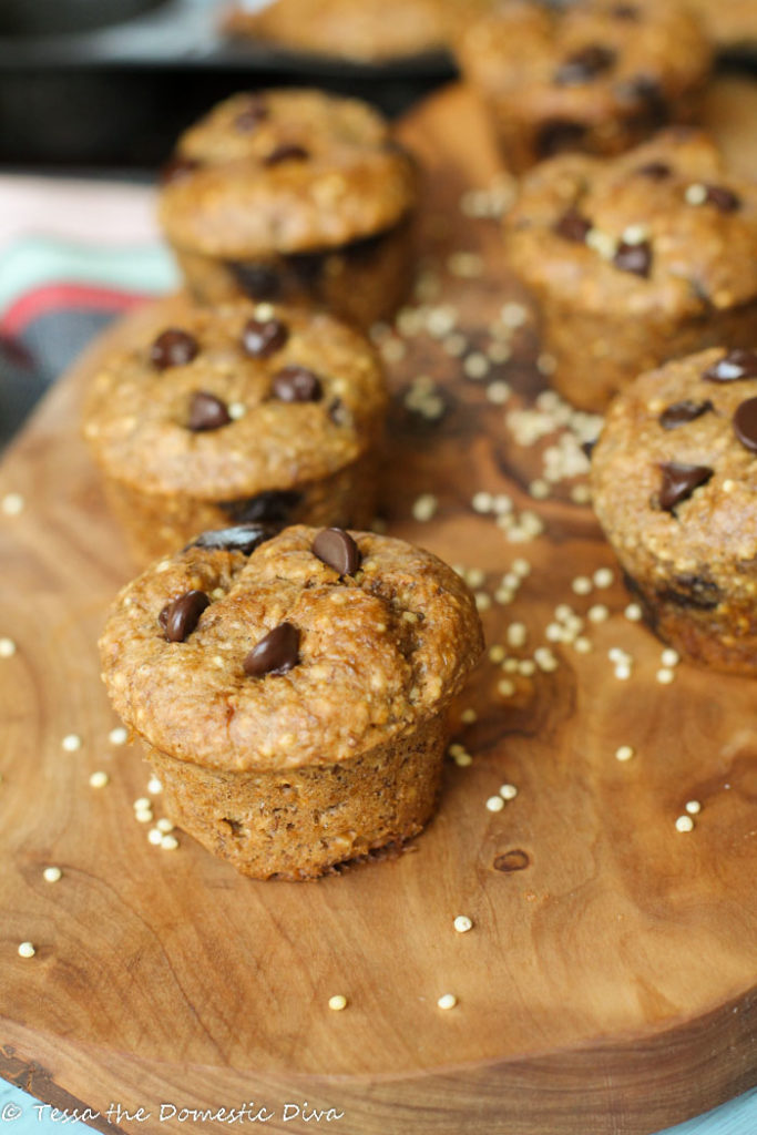 mini muffins studded with chococlate chips arranged on an olive wood cutting board with whole millet