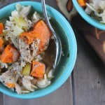 birdseye view of two aqua bowl filled with noodles, broth, carrot chunks, and celery