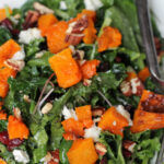 close up of a kale salad with cranberry, squash, and goat cheese
