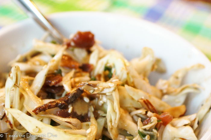 a view from above of a white bowl with a cabbage slaw with bits of bacon and sunflower seeds in a vinaigrette