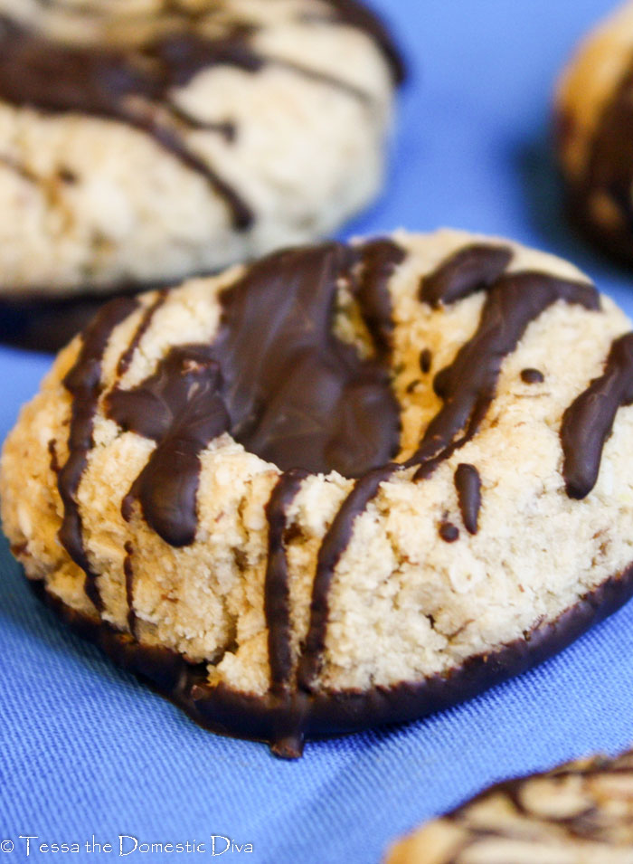 close up  of a buttery coconut cookie dipped in chocolate.