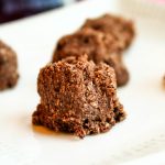 eye level raw chocolate macaroons on a white plate