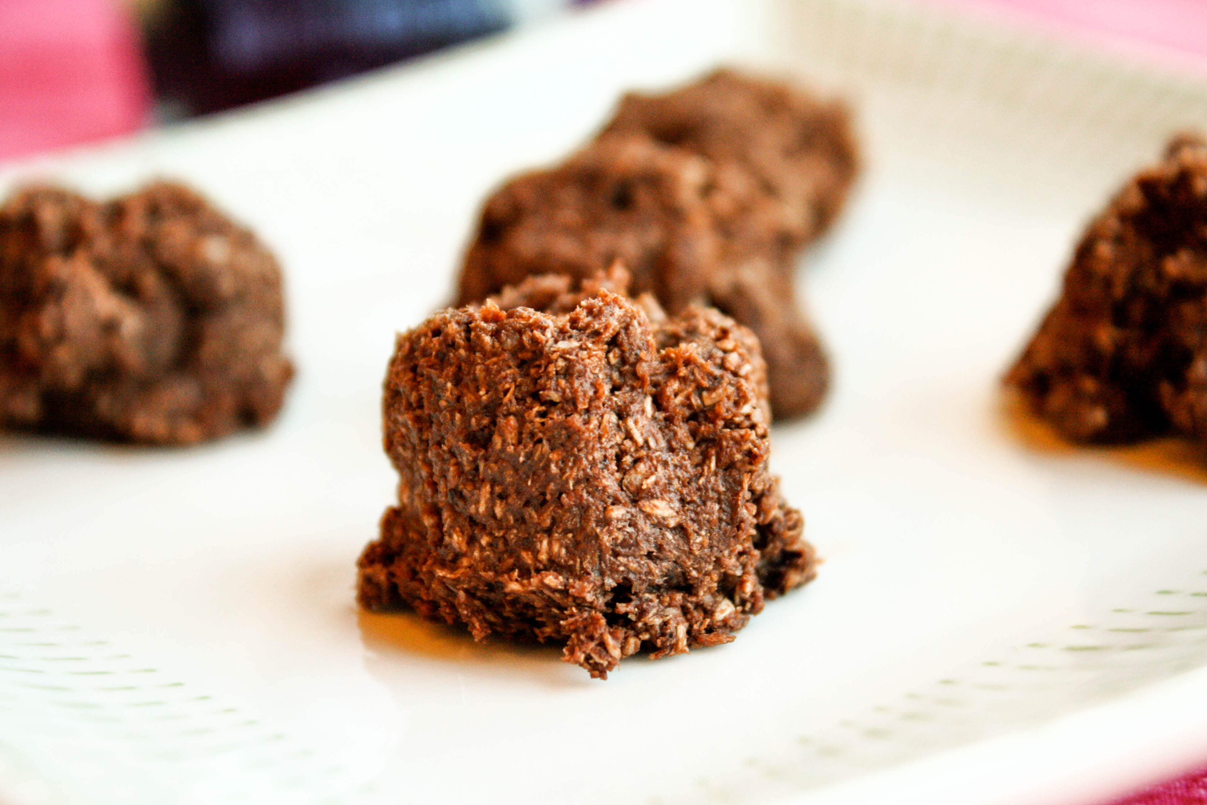 eye level raw chocolate macaroons on a white plate