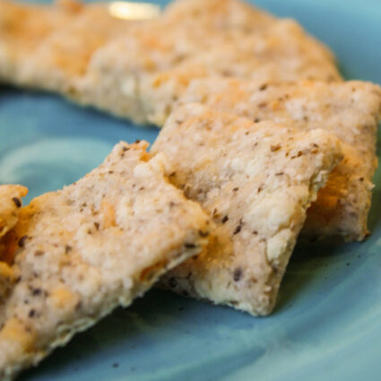 homemade dairy free cheez it crackers arranged on a turquoise plate