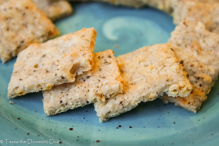 squares of dairy free cheesy crackers with specks of chia meal