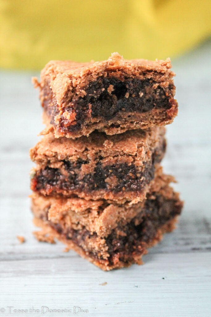 a stack three fig filled bars with a teff crust with a yellow background