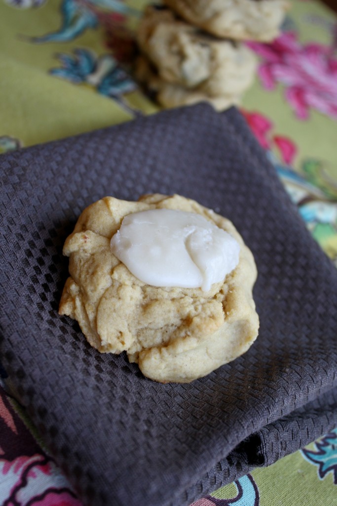 a single pumpkin cookie topped with a creamy white frosting