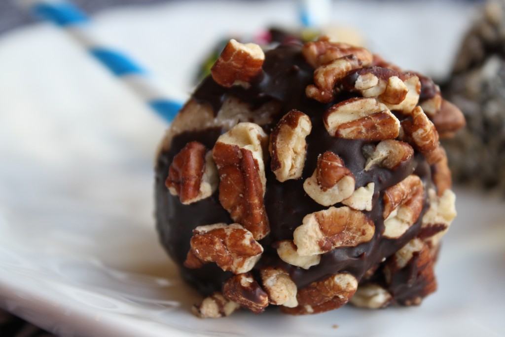 a walnut coated cooki dough pop with a chocolate coating