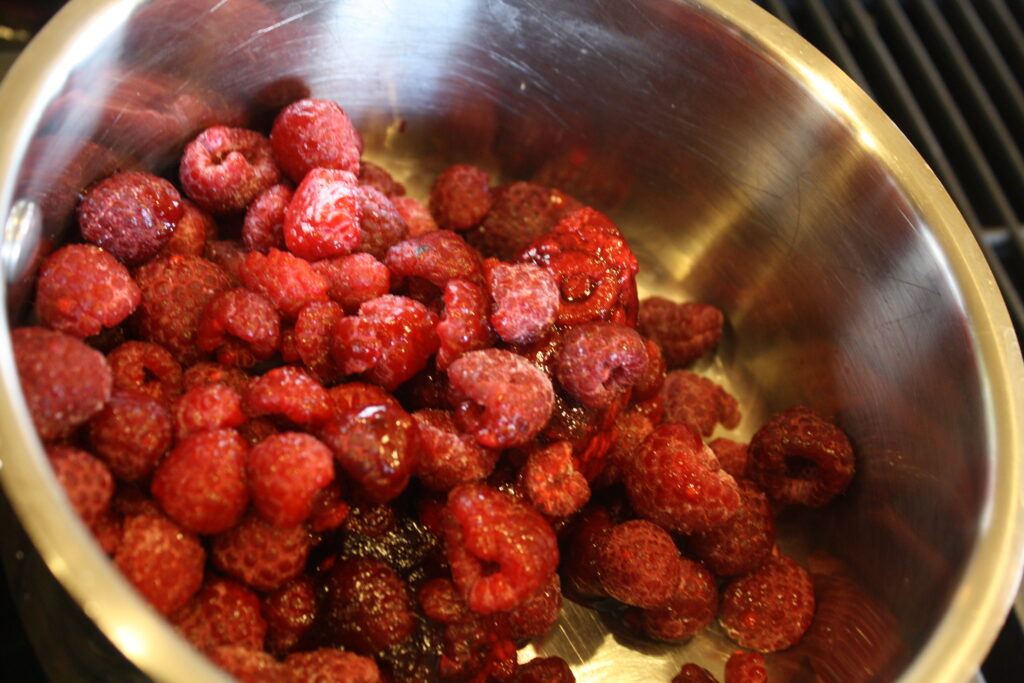 raspberries in a sauce pan with some maple syrup