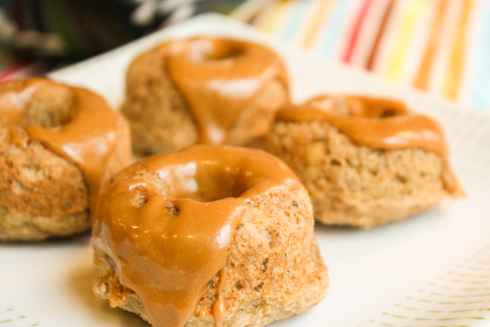 four mini glazed mini donuts atop a white plate