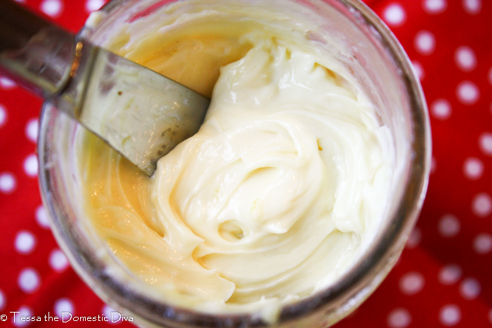 birds eye view of a clear mason jar with a pale yellow homemade mayonnaise and knife