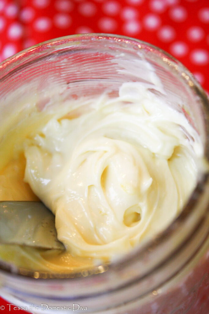 an overhead shot of homemade cream colored thick mayo in a mason jar