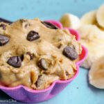 a pink silicon muffin liner filled with alow fat peanut butter dip with chocolate chips