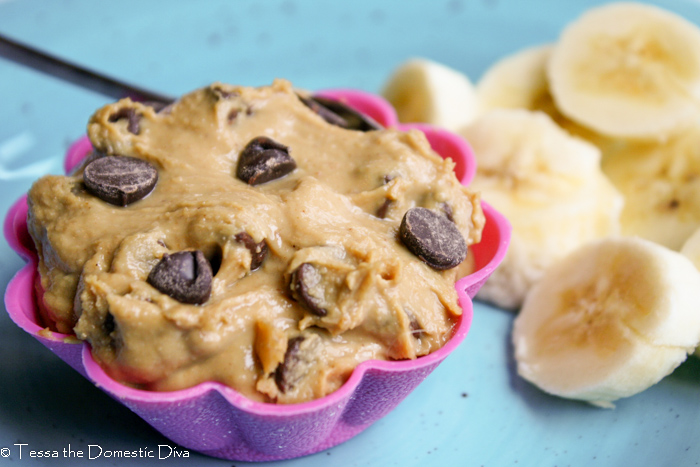 a pink silicon muffin liner filled with alow fat peanut butter dip with chocolate chips