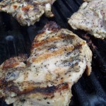 vertical image of peppered Vietnamese grilled chicken thighs on the grill