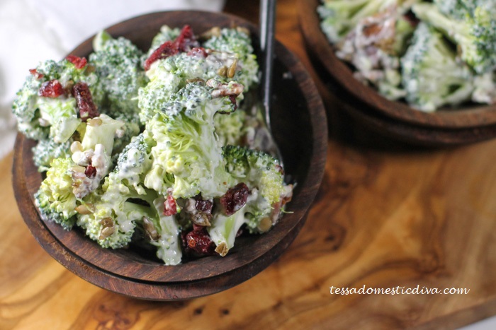 two olive wood bowls filled with a broccoli, bacon, and cranberry salad in a dairy free dressing