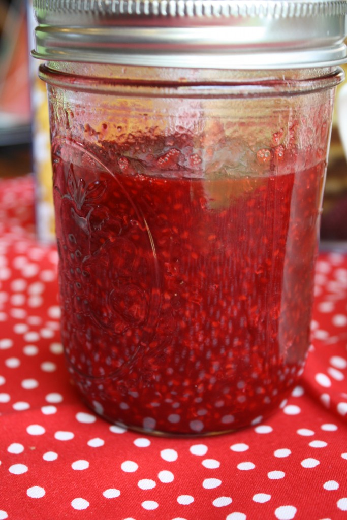 a pint mason jar filled with a raspberry syrup