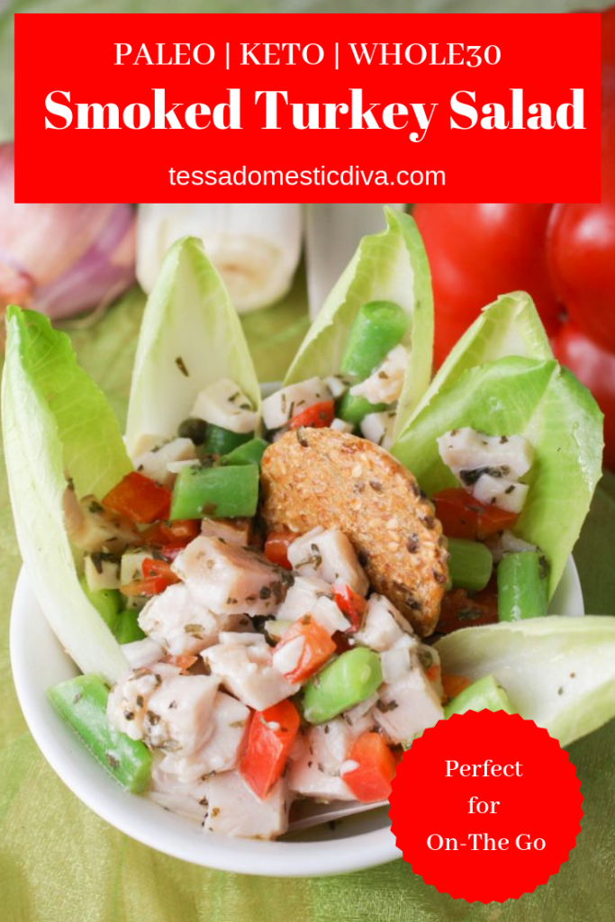 pinterest ready image of a white bowl filled with cubed smoked turkey green beans and red peppers surrounded by Belgian endive leaves