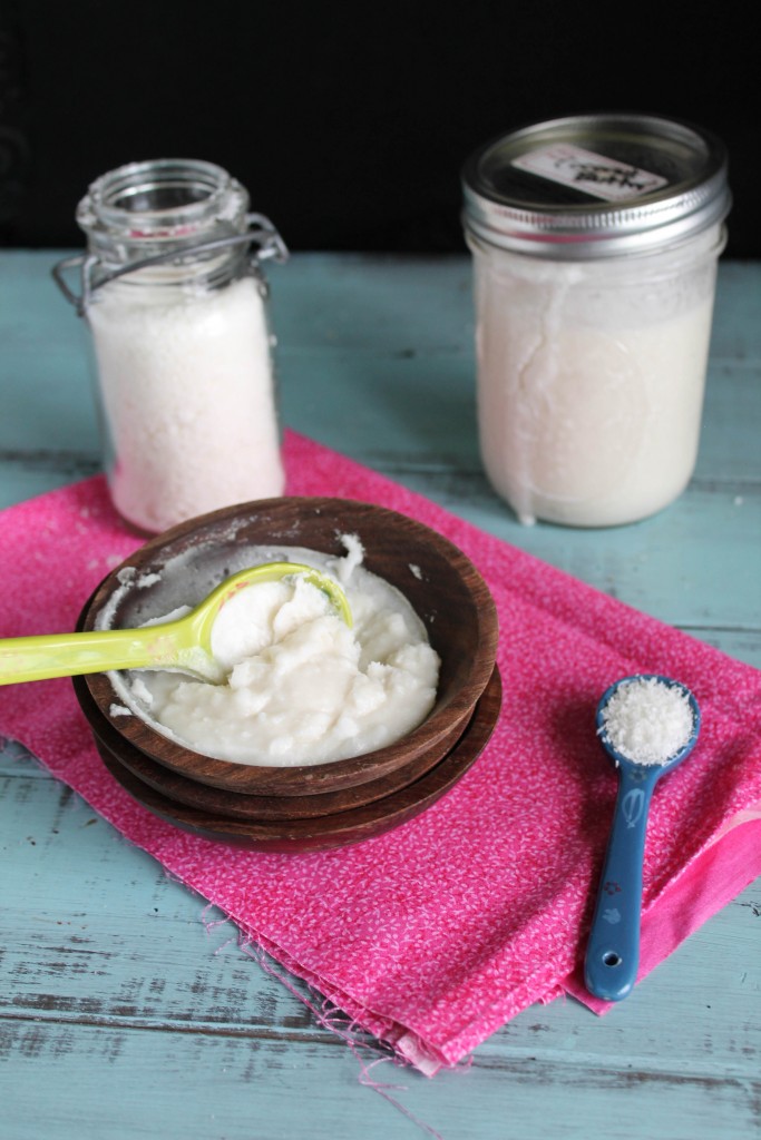 verical imgae of solidified homemade coconut butter on a pink cloth and aqua wooden plank board