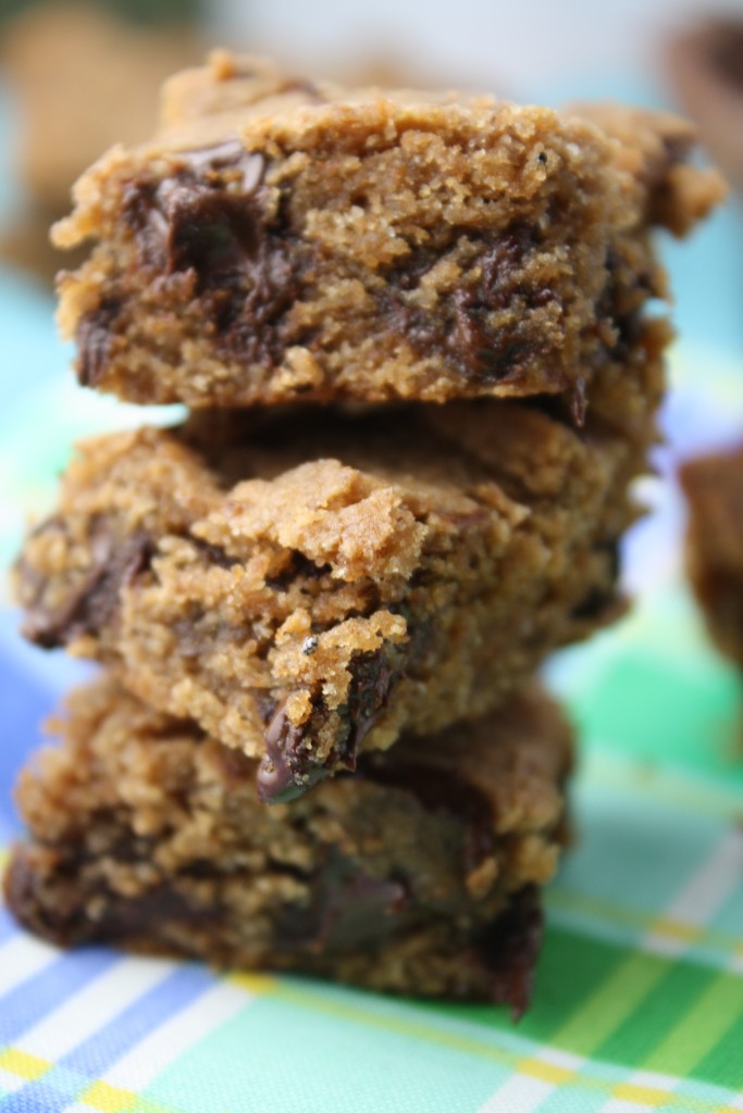 three squares of chocolate chip blondies on a lime and blue plaid cloth