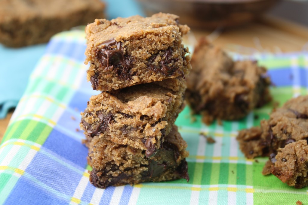 3 stacked squares of a sun butter and chocolate blondie atop a blue and green plaid cloth