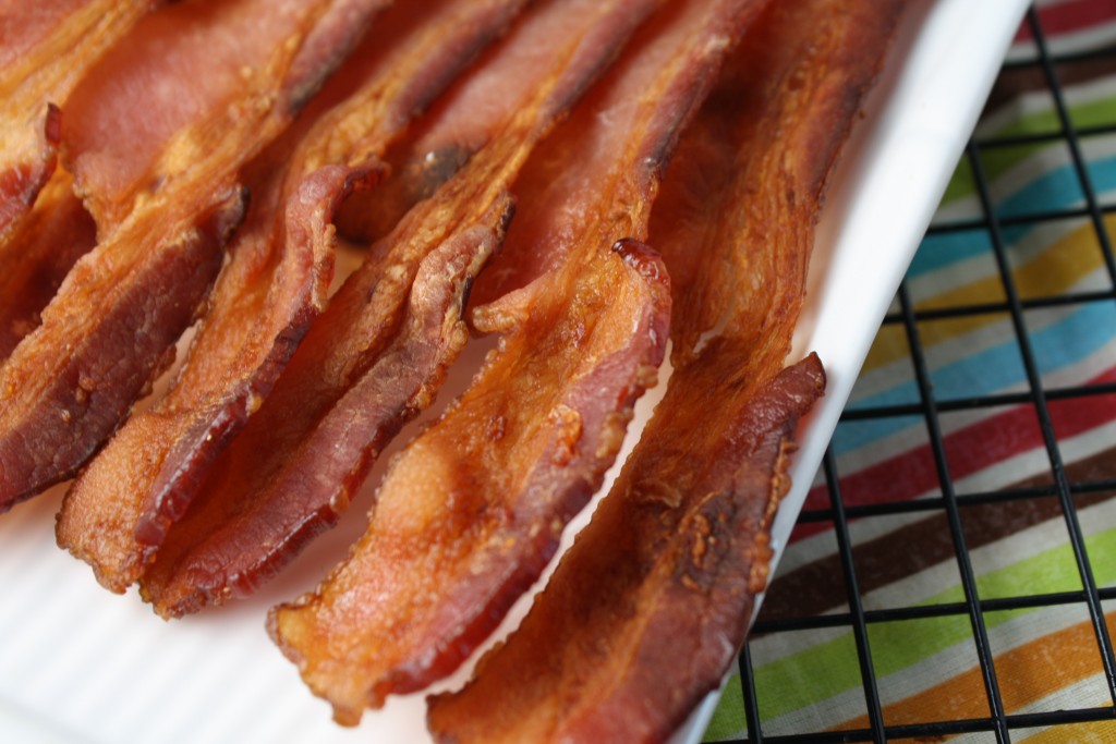 mess free crispy bacon close up on a white plate atop a rainbow striped cloth