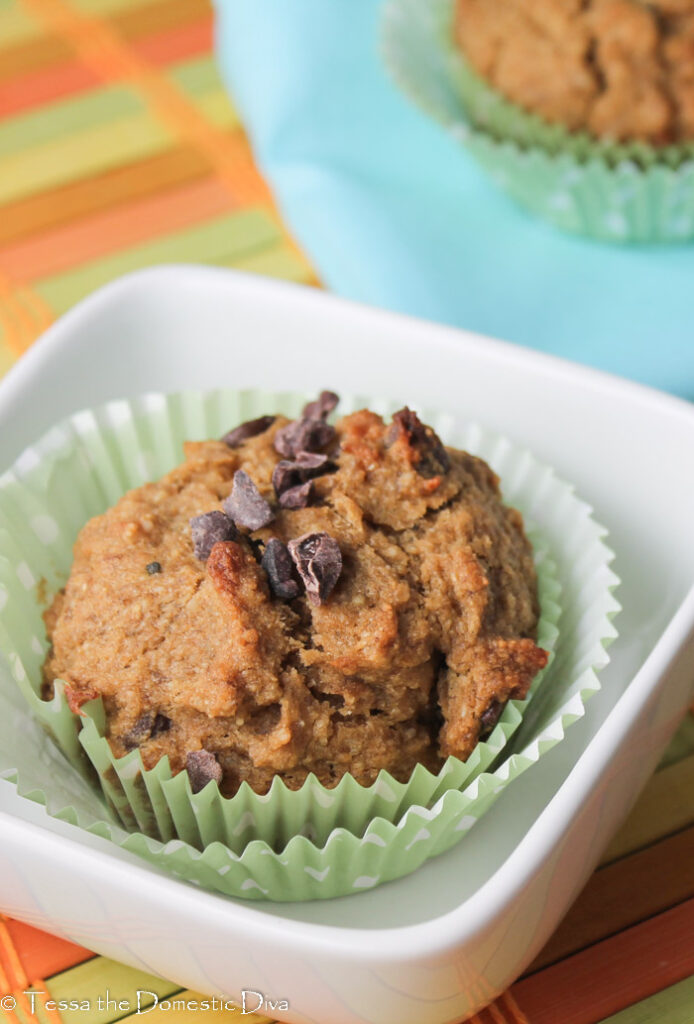 a single banana chocolate chip muffin in paleo green paper liners in a white bowl.