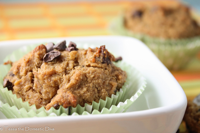 eye level close up of a cocoa nib topped banana muffin in green paper liners.