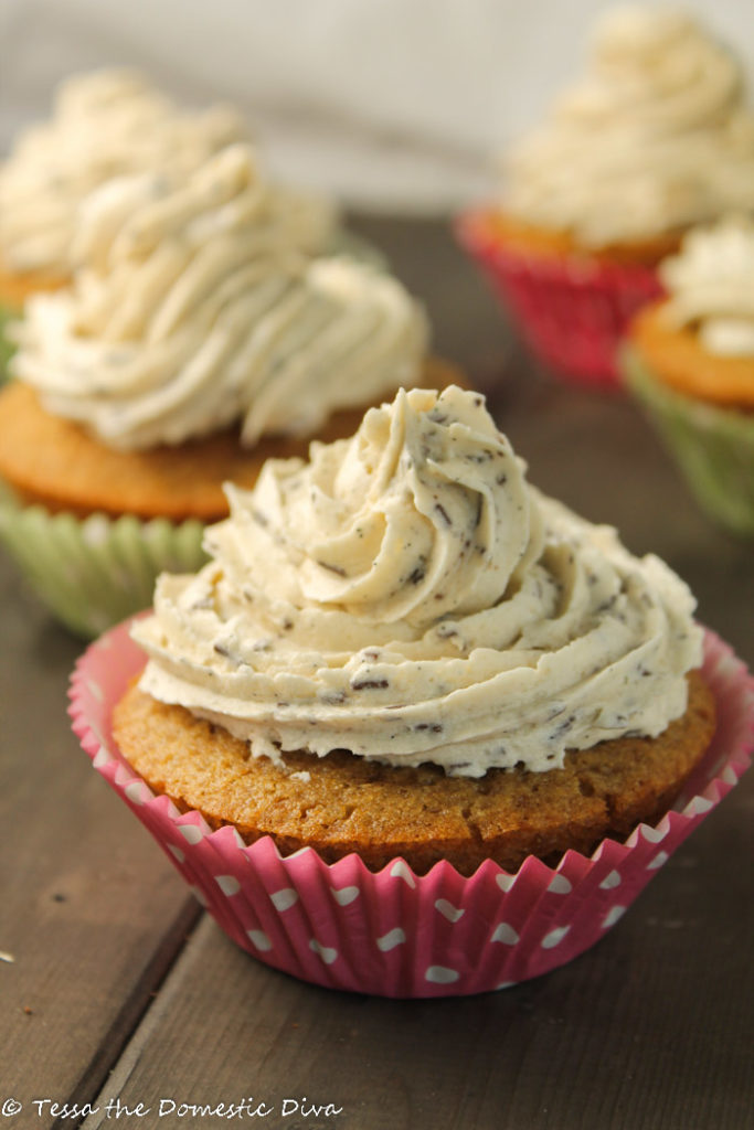 vanilla cupcakes with vanilla speckled frosting in pink with white polka dot paper liners